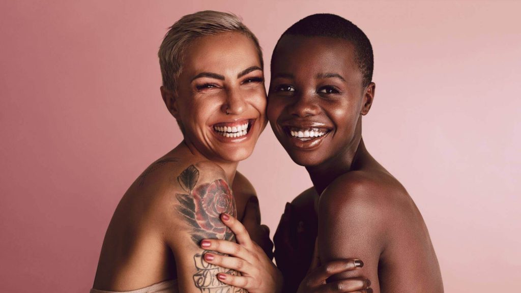 Deux femmes aux peaux mélanines souriantes représentant la diversité Beauté Backstage